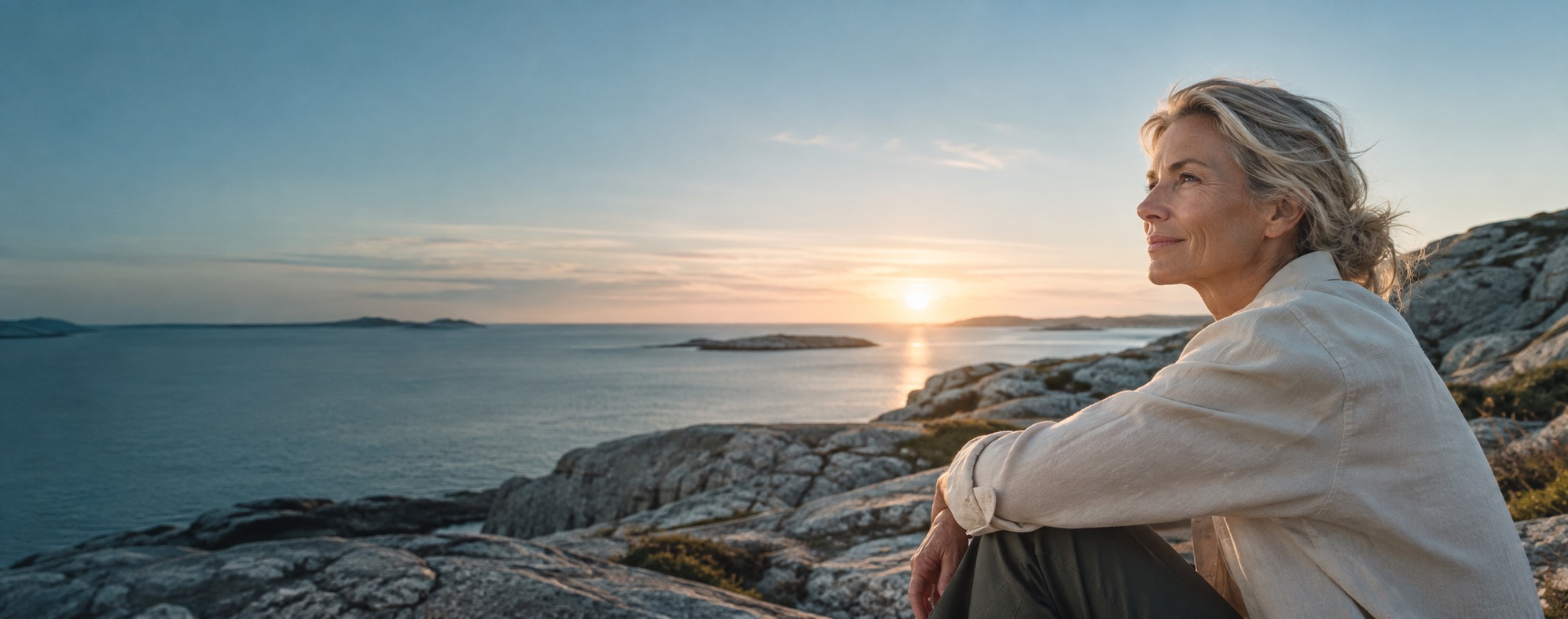 A woman looking over a Scandinavian coastline in the morning light